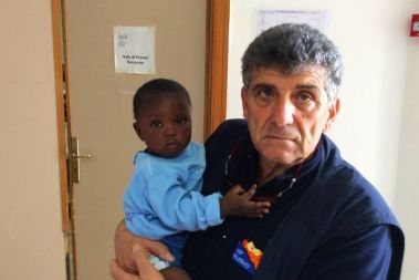 Dr Pietro Bartolo with baby Favour whose pregnant mother died of chemical burns on capsized migrant boat in 2016 © Pietro Bartolo
